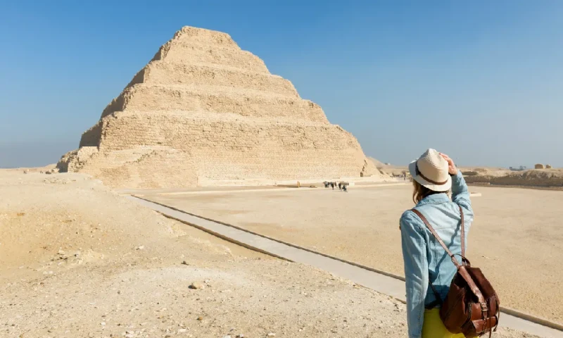 Un joven turista junto a la pirámide escalonada de Zoser en Saqqara, Egipto, pirámide de zoser.