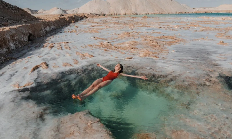 Mujer nadando en un lago salado en el oasis de Siwa, oasis de siwa