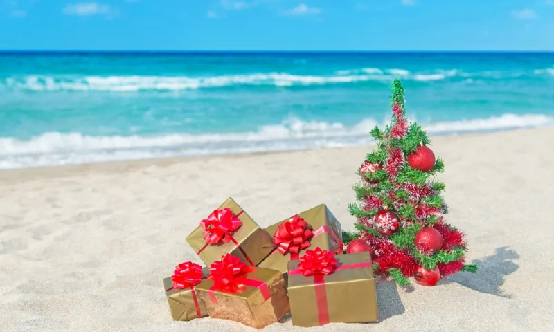 Árbol de Navidad y muchas cajas de regalo en la playa junto al mar, navidad en egipto
