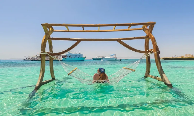 Joven descansando en una hamaca en la isla Paraíso, Egipto, mar rojo en egipto