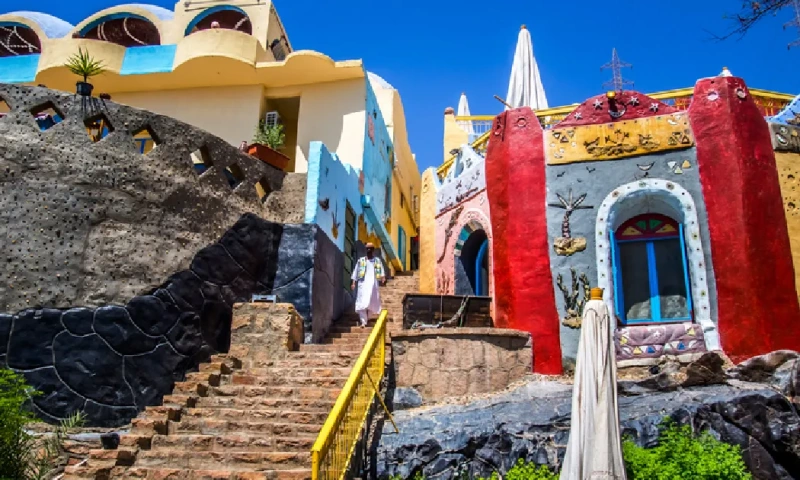 Un hombre nubio baja por una escalera de estilo tradicional nubio, pueblo nubio