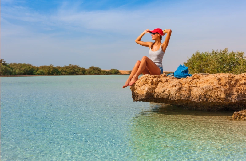Viaggio Giordania, una donna siede a una roccia a un lago
