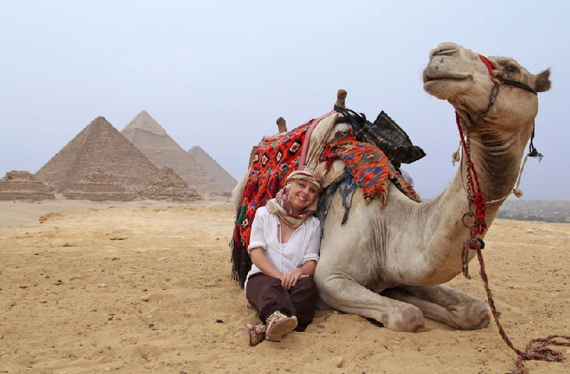 Una donna accanto a un cammello alle piramidi, egitto pasqua 2026