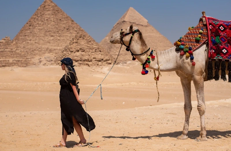 una donna con un cammello alle piramidi, viaggio cairo e luxor