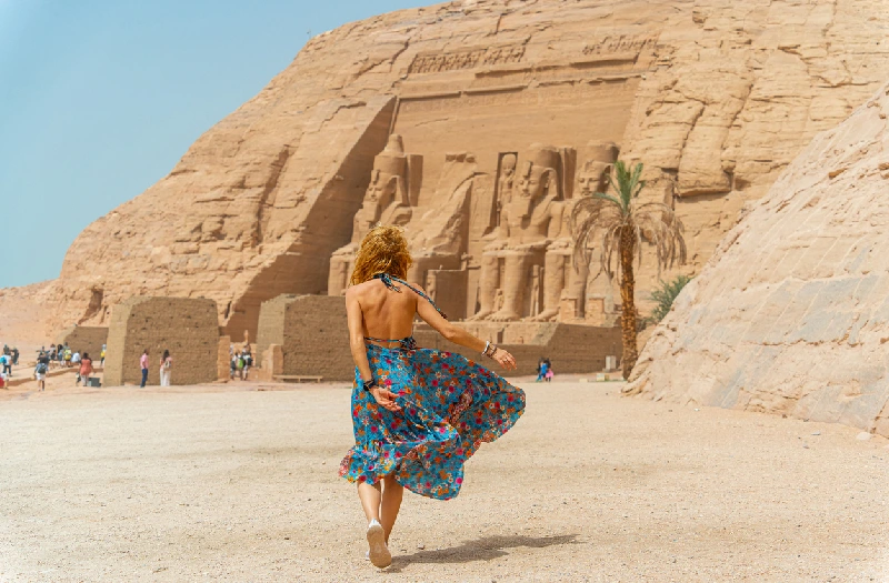 Mujer entrando al increíble Templo de Abu Simbel reconstruido en la montaña en el sur de Egipto en Nubia junto al lago Nasser Egipto, Asuán, Abu Simbel.