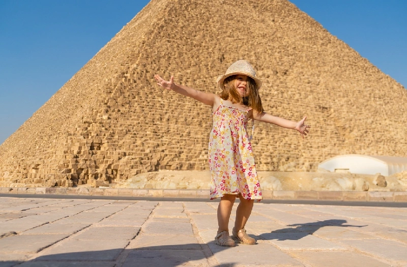Linda niña bailando frente a la pirámide de Keops en Giza