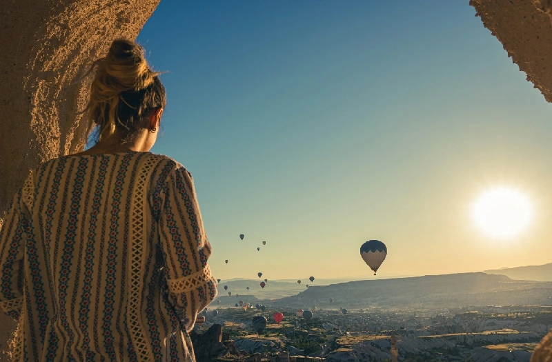 Turista observando globos aerostáticos en Capadocia