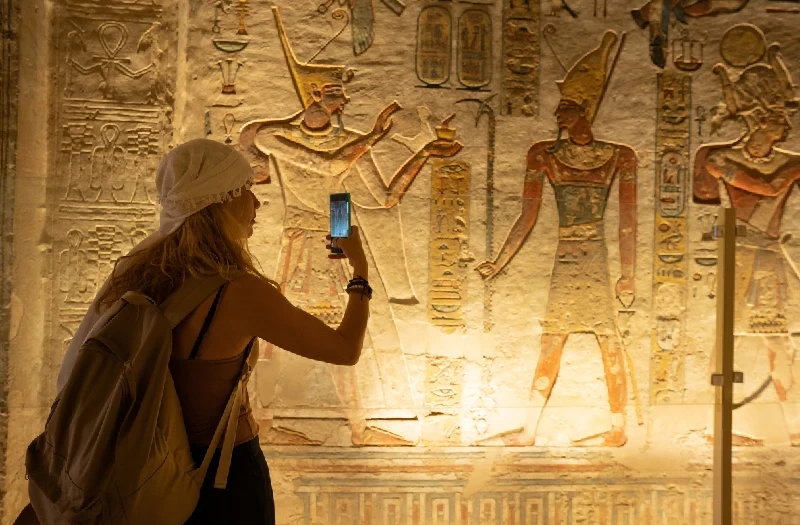 Mujer tomando una fotografía durante su visita al Valle de los Reyes