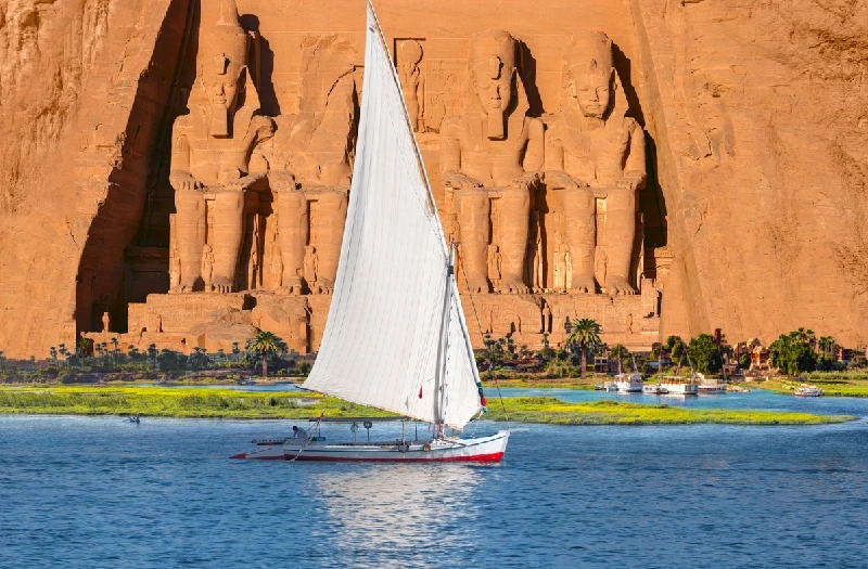 Templos de Abu Simbel con una faluca navegando por el Nilo.