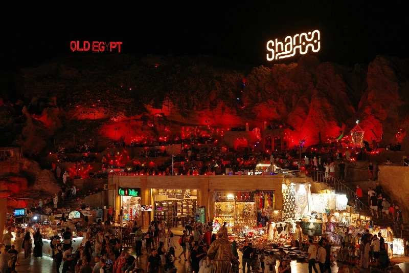 Vista nocturna del Old Market de Sharm el Sheikh con luces, comercios y visitantes.