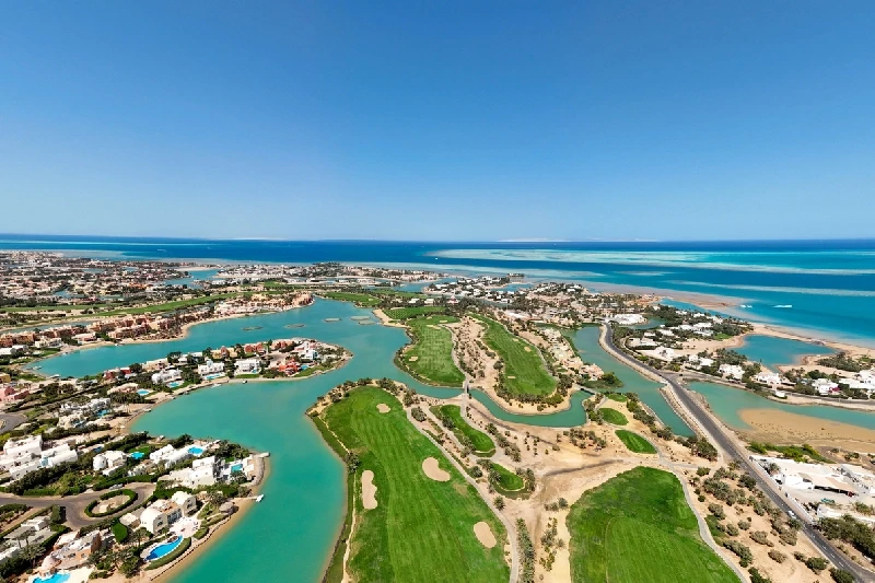 Amplia toma aérea que muestra un gran campo de golf integrado con lagunas y áreas residenciales en El Gouna.