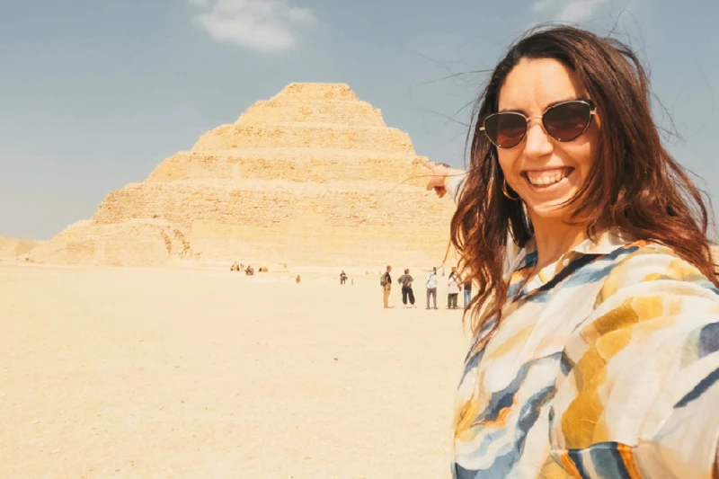 una mujer tomando foto con la Pirámide de Saqqara