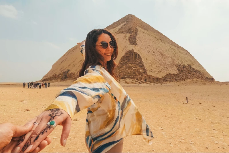 mujer coge la mano de su hombre delante de la Pirámide Escalunada en Saqqara