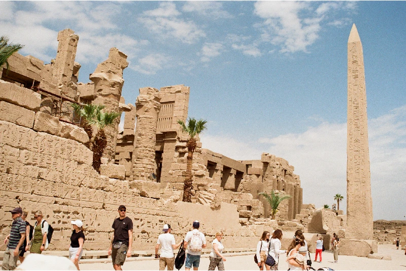 touristas delante del obelisco en el Templo de Karnak en Luxor