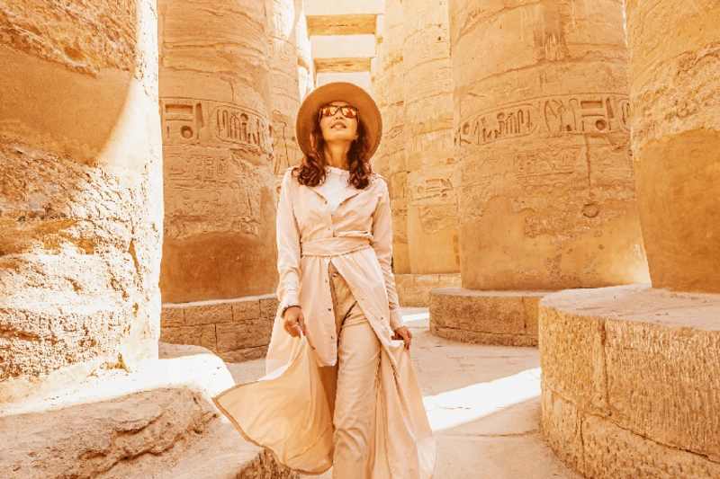una mujer Caminando entre unas columnas del Templo de Karnak