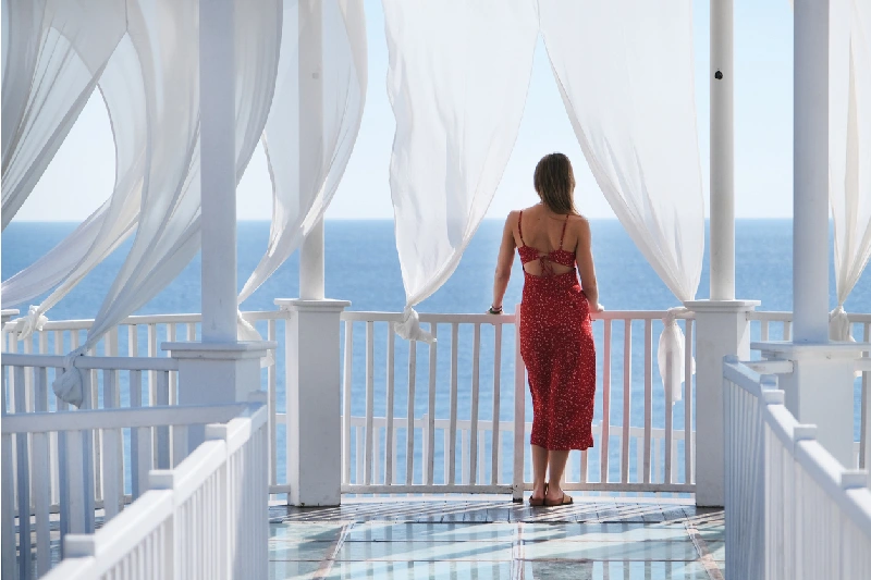 una mujer en una terraza con cortinas blancas en un Crucero por Nilo