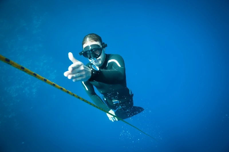 Persona practicando buceo libre en el Blue Hole de Dahab, Egipto, rodeado de aguas azules profundas.