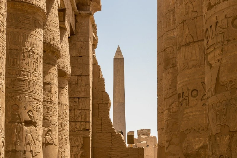 Obelisco de Egipto rodeado por columnas con jeroglíficos en el Templo de Karnak.