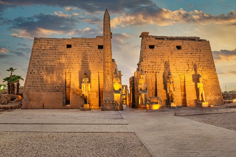 Obelisco de Egipto frente al Templo de Luxor iluminado al atardecer.