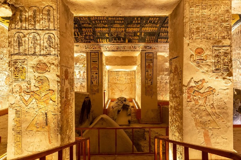 Interior de tumba egipcia con paredes decoradas con jeroglíficos.