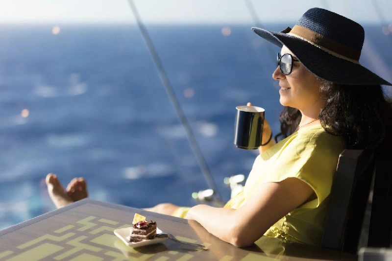 Viajera disfrutando de una bebida en la cubierta de un crucero mientras navega por el río Nilo, una de las experiencias más populares en Egipto.
