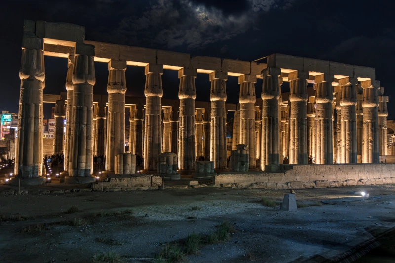 Templo de Luxor iluminado por la noche con la visita de turistas