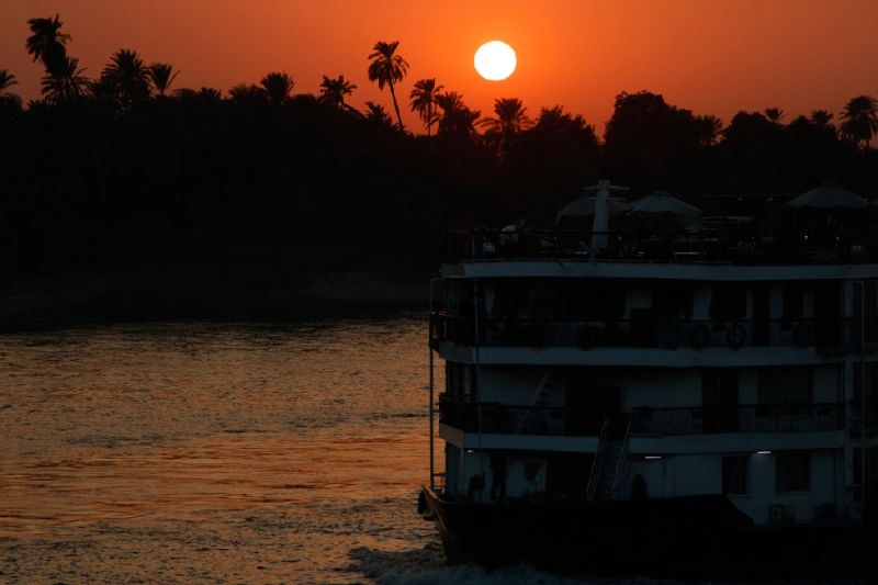Puesta de sol en el río Nilo con un crucero navegando en el agua