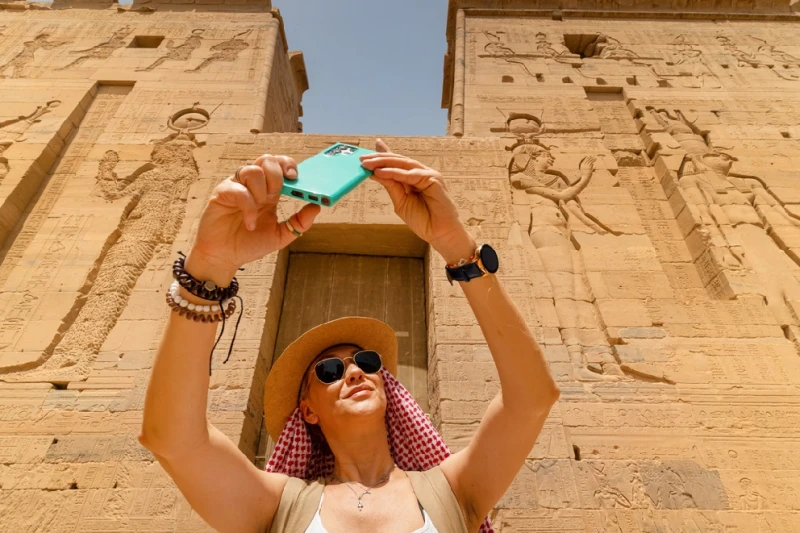 Templo de Filae Una mujer turista tomando foto enfrente de la fachada del Templo de Filae