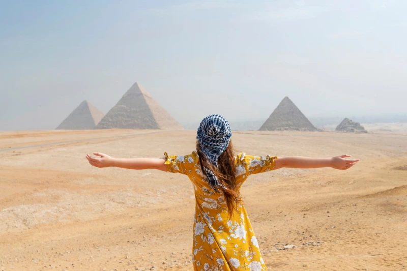 Las Pirámides de Giza una mujer turista tomando una foto enfrente de las pirámides de Giza en Egipto