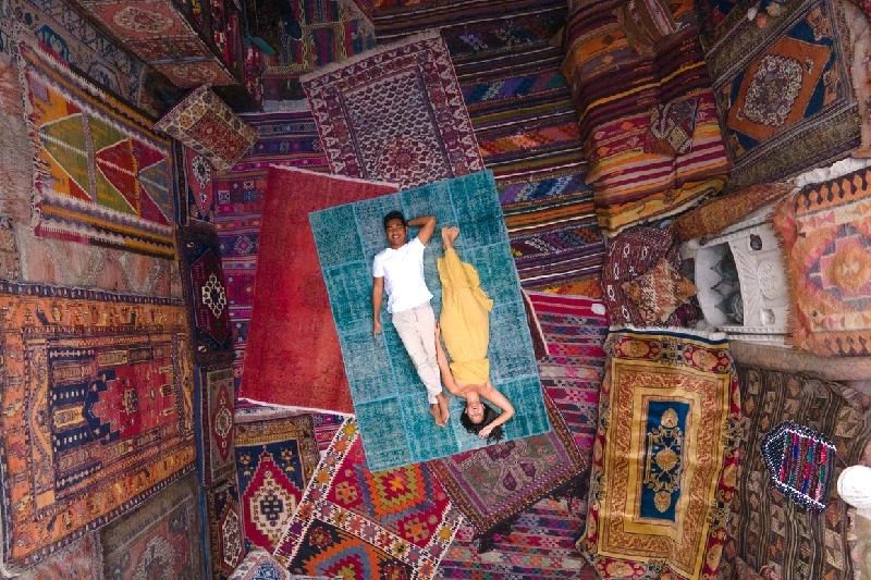 ChatGPT said:  Drone shot of a couple on a carpet surrounded by vibrant rugs in Cappadocia.