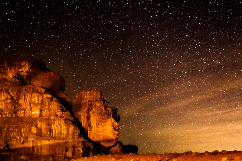 Muchas estrellas sobre la montaña en el desierto de Wadi Rum.