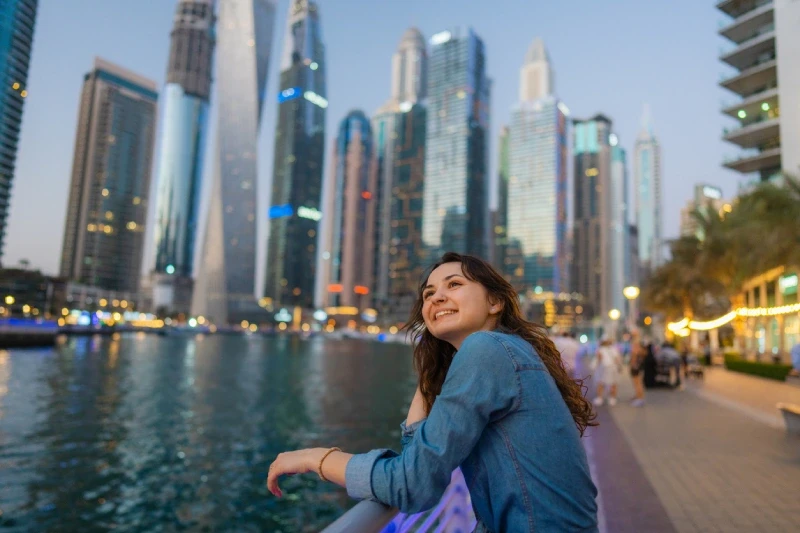 A happy traveler taking in the beautiful Dubai Marina scenery.