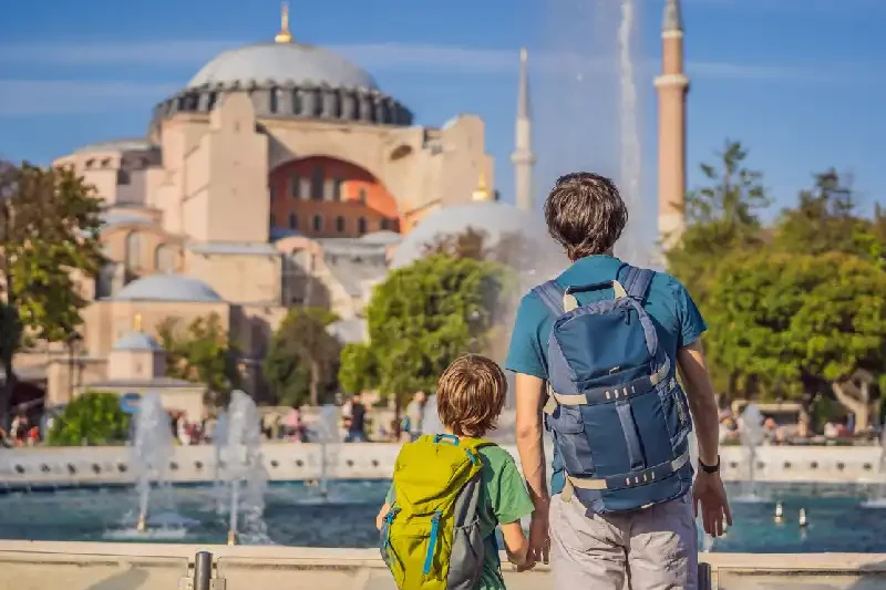 Parent and his child admiring the historic Hagia Sophia in Istanbul.