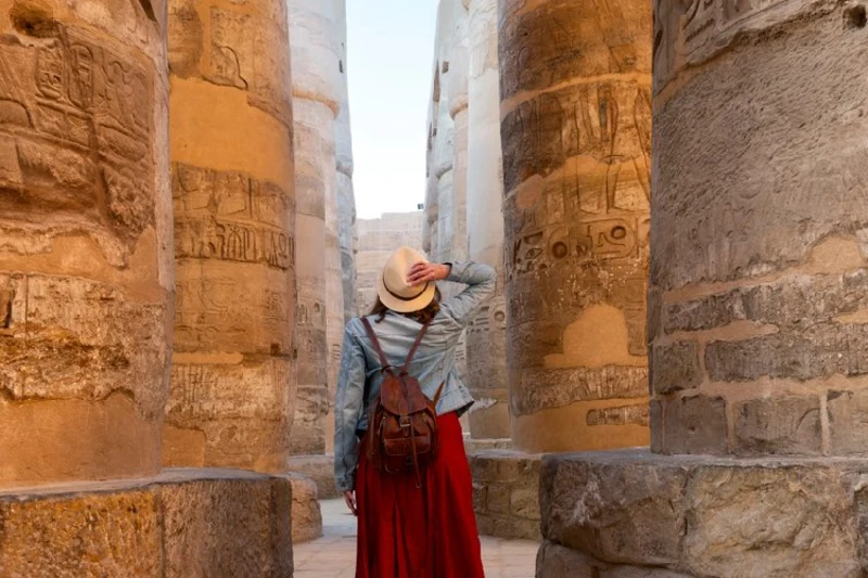 Visitante recorriendo el Templo del Valle Egipto entre antiguas columnas con jeroglíficos.