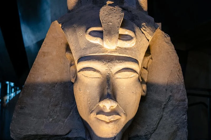 Busto del faraón Ajenatón iluminado en una sala de museo dedicada al Antiguo Egipto.