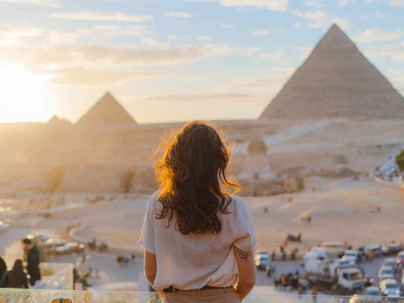 Voyageuse face aux pyramides de Gizeh sous le soleil d'hiver, l'Égypte en janvier