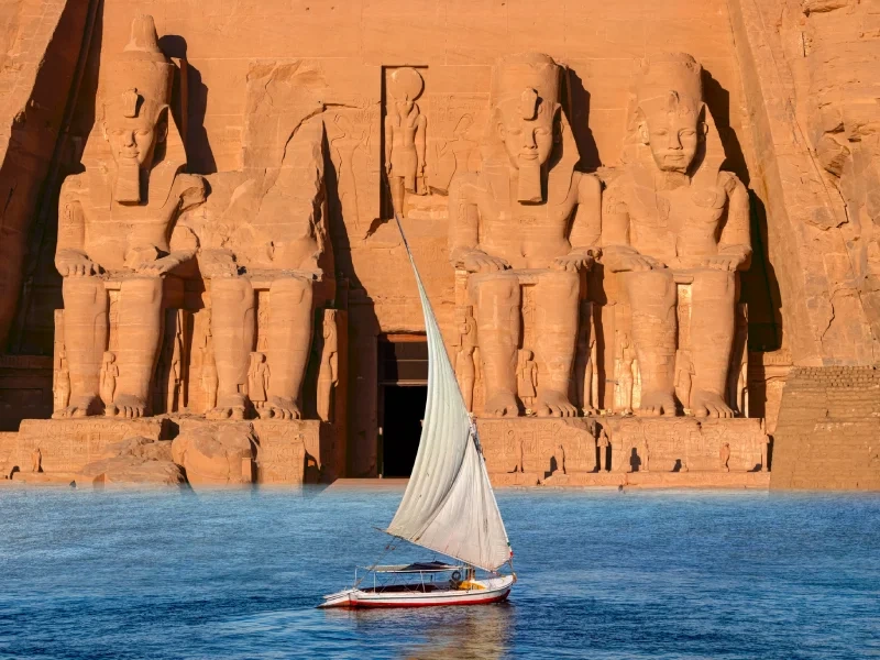Felouque sur le Nil devant les colosses de Ramsès II du temple d'Abou Simbel