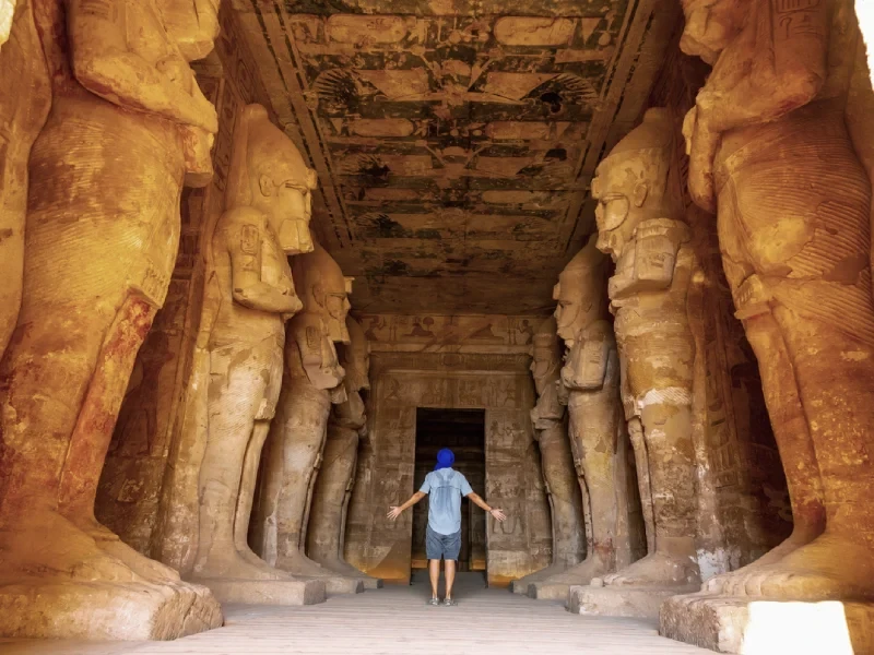 Voyageur dans la salle hypostyle du grand temple d'Abou Simbel, bordée de piliers osiriaques