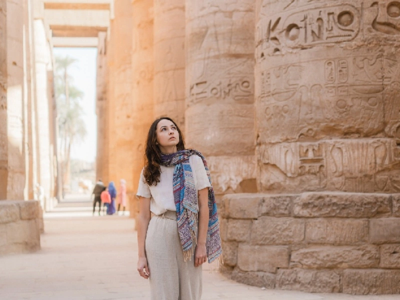 Mujer caminando en el antiguo templo egipcio de Luxor