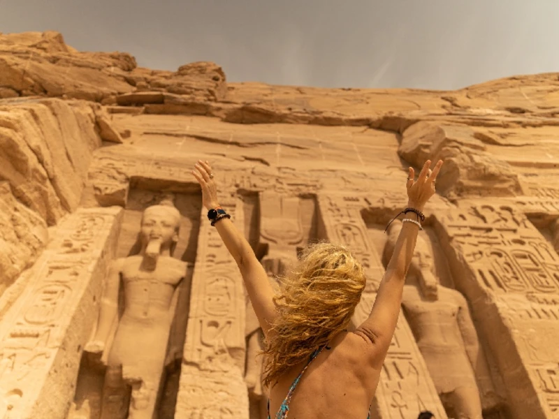 Mujer de pie frente al templo de Hathor y Nefertari, en Abu Simbel, Egipto