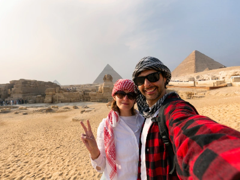 Pareja de viajeros en las Pirámides de Guiza, Egipro durante el tour de Fin de Año.