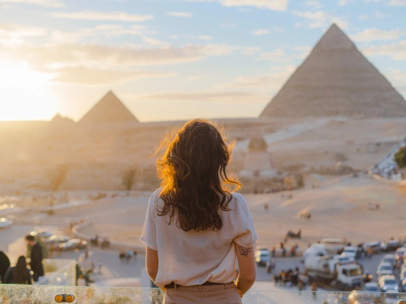 Ritratto di una ragazza di spalle mentre ammira la vista panoramica completa del complesso di Giza.