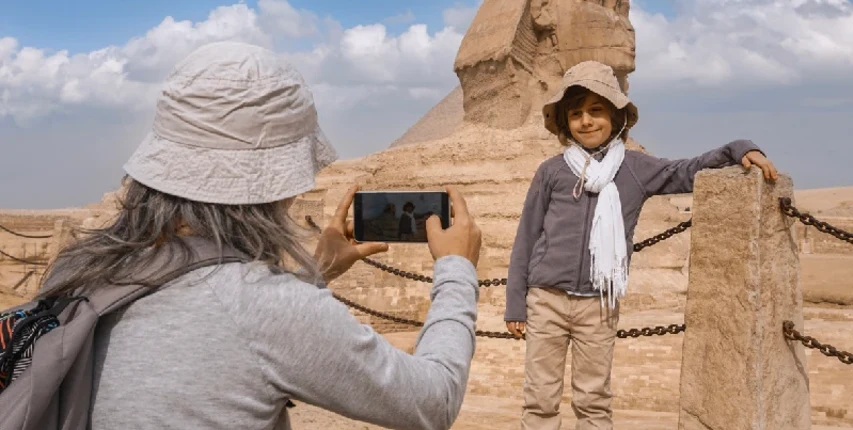 Kind wird vor der Großen Sphinx von Gizeh fotografiert