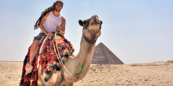 Un uomo su un cammello nella zona delle Piramidi di Giza, cose da vedere il Egitto