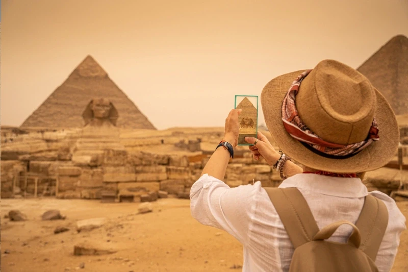 Una donna che scatta una foto per le piramidi, cose da vedere in egitto