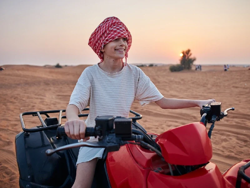 Young boy driving a buggy across the Dubai desert. Young boy driving a buggy across the Dubai desert.