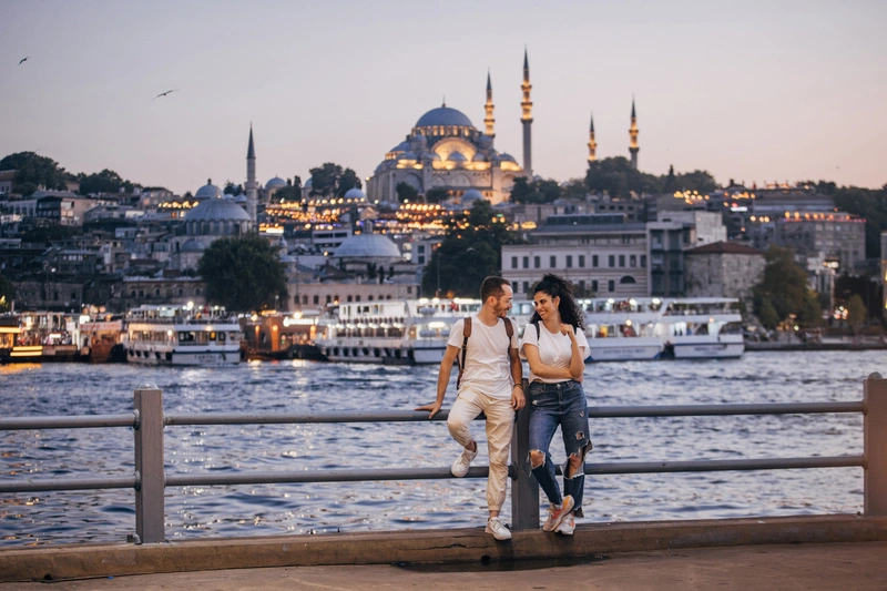 Pareja disfrutando de la vista nocturna del paseo marítimo de Estambul, Turquía