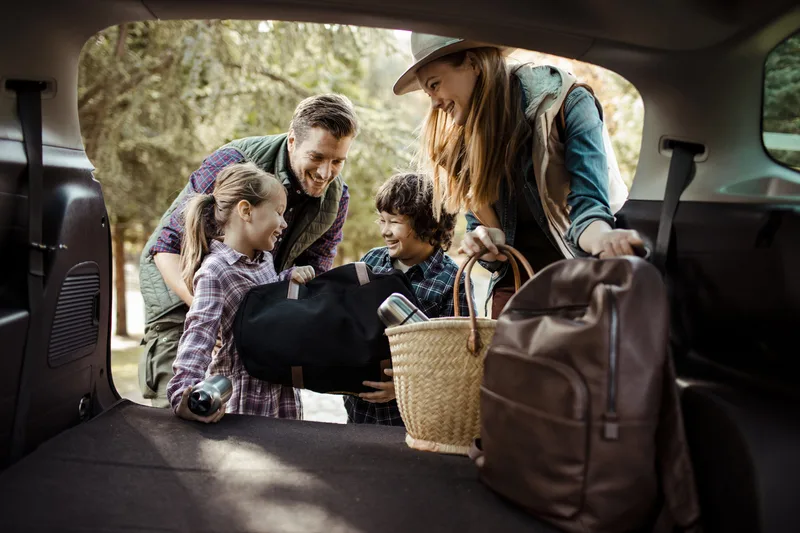 Una familia joven preparándose para un viaje por carretera Una familia joven preparándose para un viaje por carretera