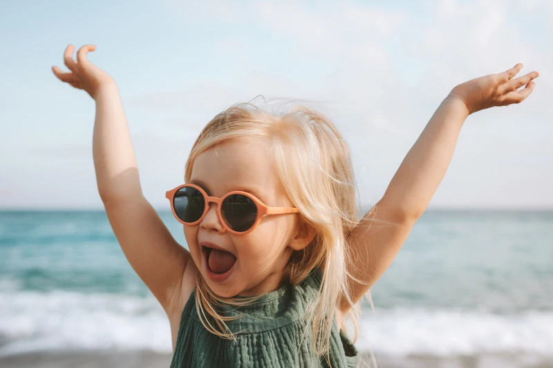 Niña jugando al aire libre con gafas de sol Niña jugando al aire libre con gafas de sol