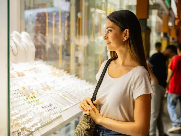Woman admiring gold jewelry in Deira Gold Souk.